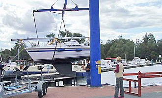 Ein Boot wird mit einem Kran zu Wasser gelassen