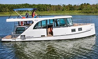 unser Hausboot Aquino auf einem See mit einer Frau am Steuer